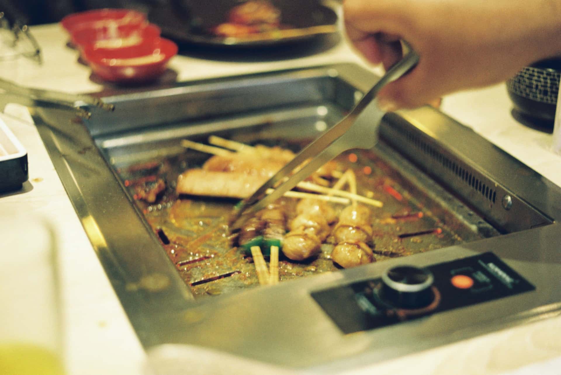 Metal kitchen tongs over a heat source