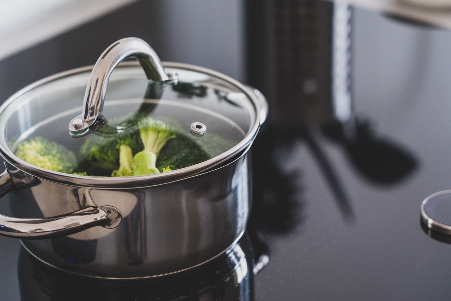 A large stainless steel pot with a lid on a stove