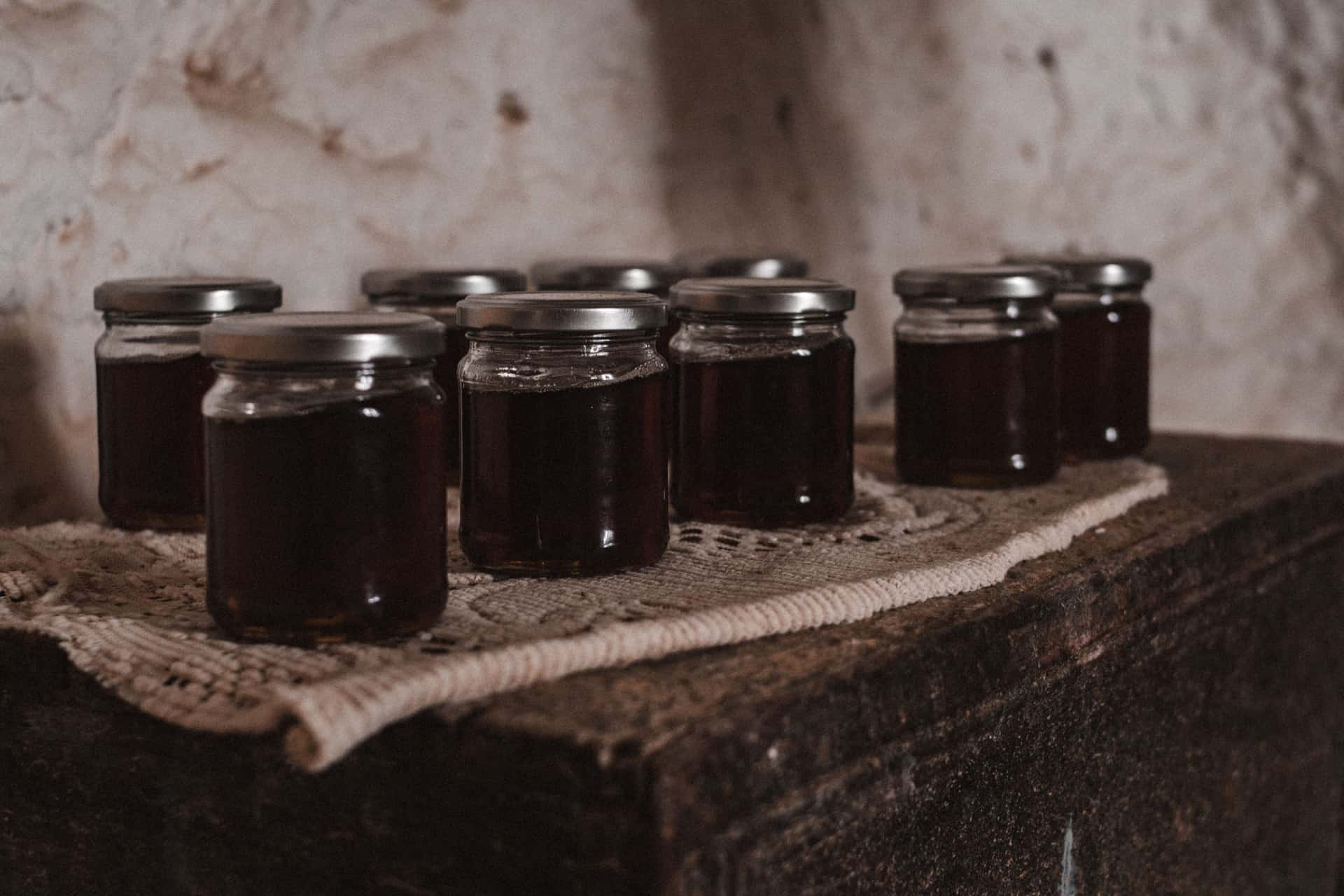 Jars of preserves photographed against a dark background